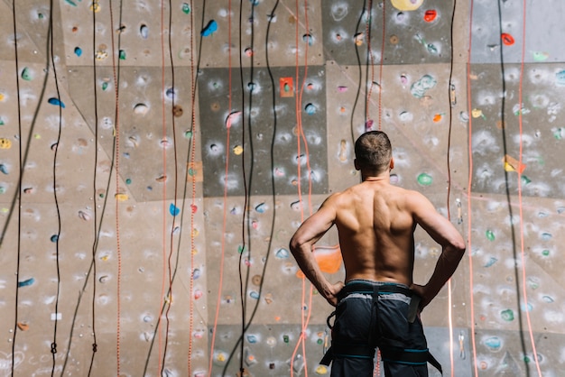 Back view man looking at climbing wall