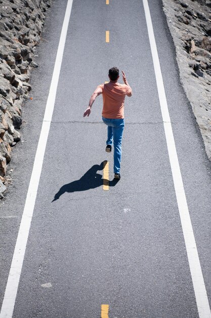 Back view of man runner running at road workout urban\
concept