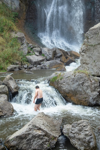 Back view of man in small waterfall