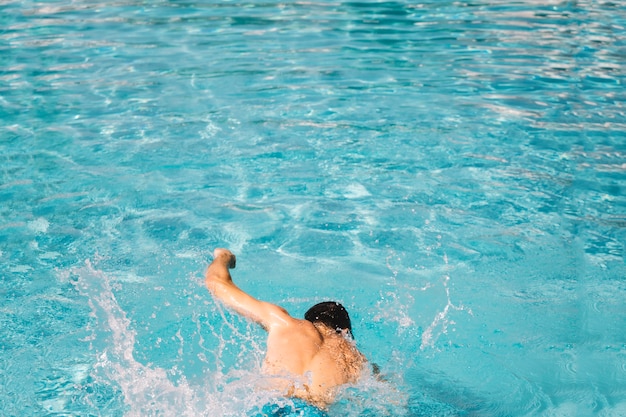 Back view of man swimming