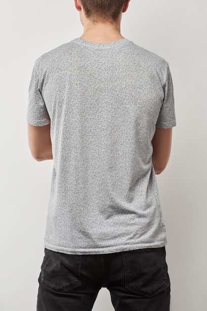 Photo back view of man in tshirt with copy space isolated on grey