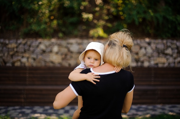 Back view of mother holding her little baby