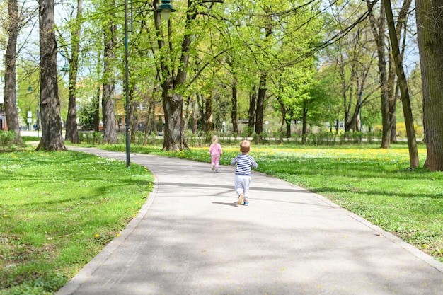 写真 公園でoutoodrsを歩いている子供たちの背面図