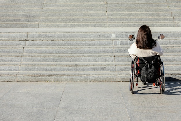 写真 階段に近づく車椅子の女性の背面図