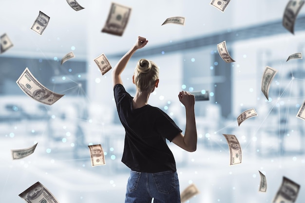 back view of oung successful woman with dollar bill money rain on blurry office interior background success money and lottery winner concept