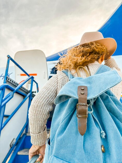 Back view of passenger outside the airplane ready to enter and enjoy the travel to next holiday vacation destination Backpacker alone female traveler concept lifestyle Flying on airplane Flight