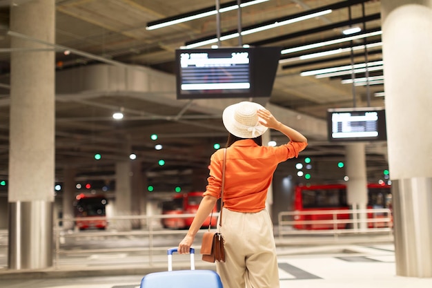 Back view of passenger woman standing at modern bus station