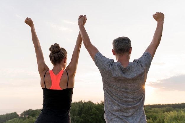 Foto vista posteriore persone che si tengono per mano vittoriosamente