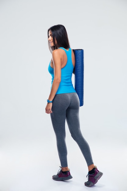 Back view portrait of a woman with yoga mat