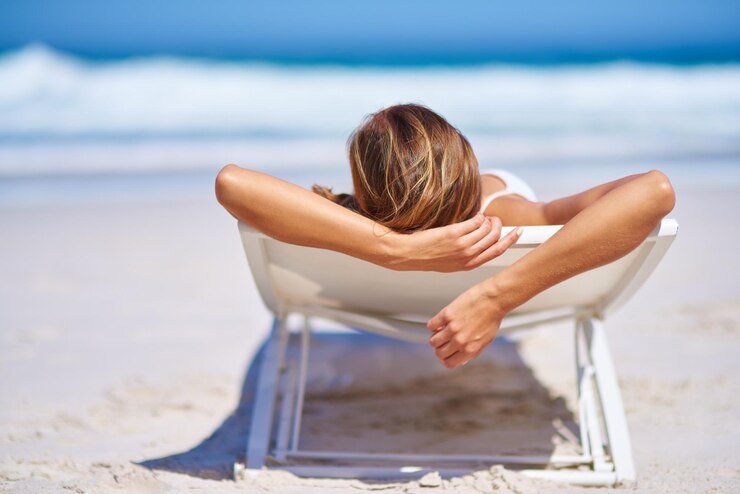 Photo back view relax and woman on chair at beach for adventure holiday or sunshine at tropical resort in maldives female person island and travel on vacation peace or blue sky for sunbathing