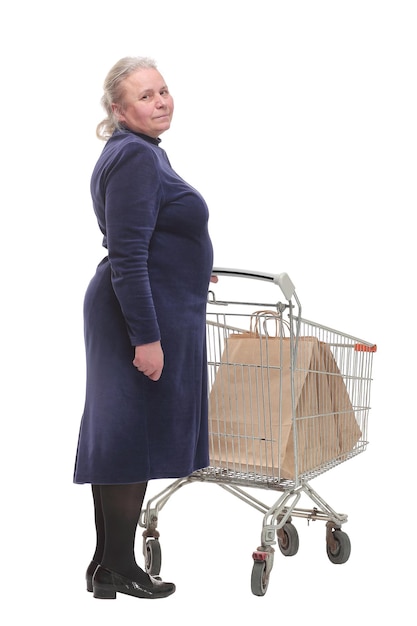 Back view of senior woman shopping at the supermarket and pushing a cart