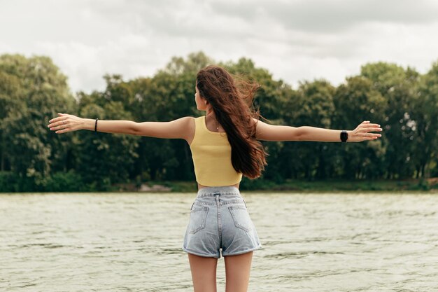 Foto vista posteriore sottile donna stand nel fiume mare lago femmina sull'isola della spiaggia spruzzi onde schiuma