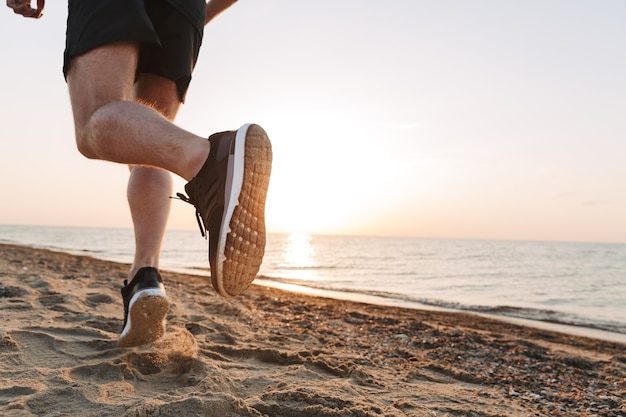 Vista posteriore delle gambe di uno sportivo in esecuzione