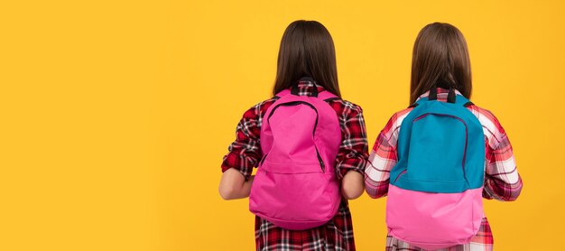 Back view of teen girls in casual checkered shirt carry backpack knowledge Portrait of schoolgirl