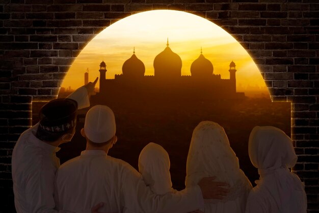 Back view of three generation Muslim family looking at mosque