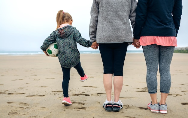 Back view of three generations female watching the sea in autumn