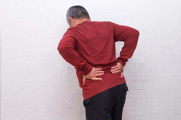 Back view of tired old man suffering from lower back pain