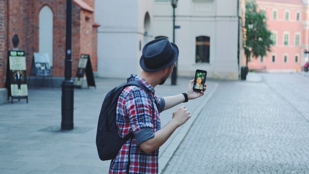 Back view of tourist making video call with female tourist from other place. They exchanging impressions from travelings.