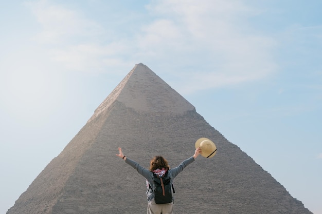 Back view of tourist woman standing in front of a pyramid Egypt Cairo Giza