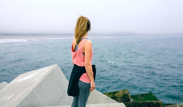 Punto di vista posteriore della giovane donna irriconoscibile che guarda il mare