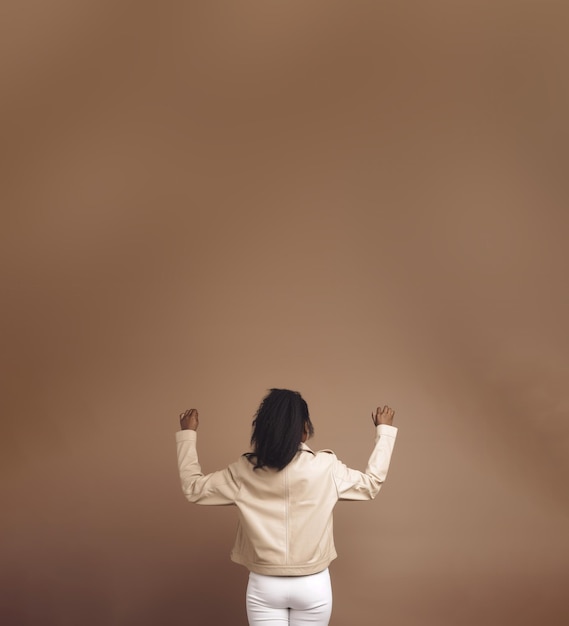 Back view of a woman over a brown background