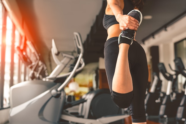 Back view of woman doing yoga in fitness sport training club with sport equipment