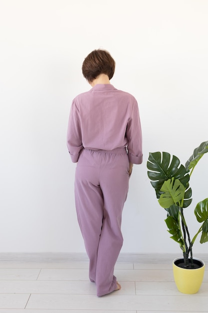 Back view of woman dressed in beautiful colorful pajama posing as a model in her living room