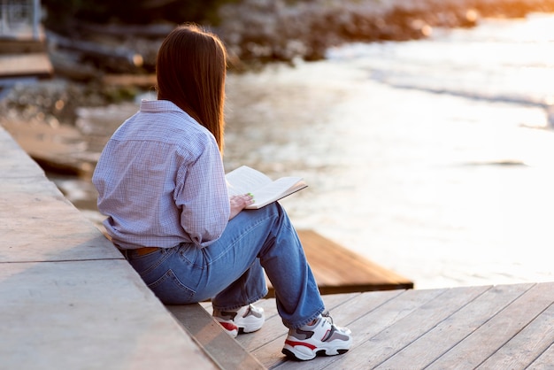 Back view woman holding a book with copy space