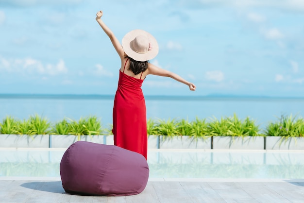 Back view of woman stretching and  relaxing by swimming pool