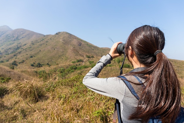 The back view of woman use of the binocular