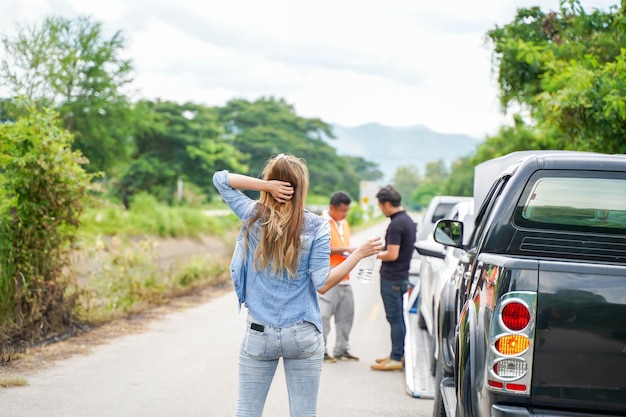 Back view of woman waiting her husband with car slide after car accidents on road side