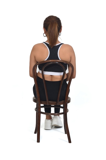 Back view of women sitting on chair with sportswear on white background