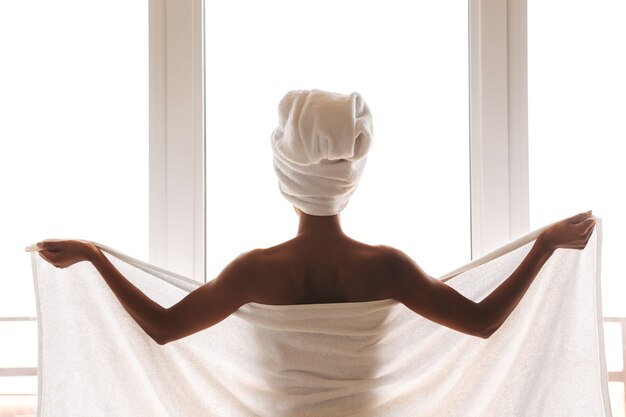 Back view of a young african woman wrapped in a towel