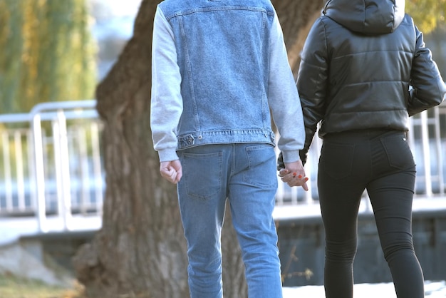 Back view of young couple walking on city street enjoying time together