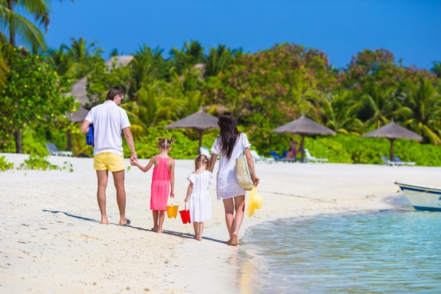 Back view of young family on beach during summer vacation