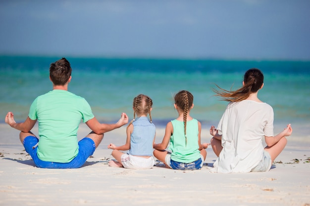 Back view of a young family on tropical beach