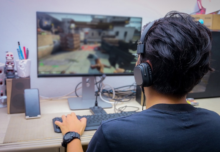 Photo 一名年輕玩家在玩 fps 視頻遊戲的後景
