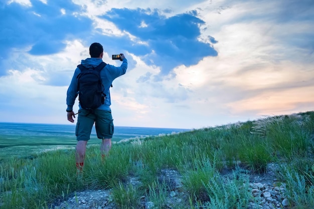 Back view young male hiker looks at horizon