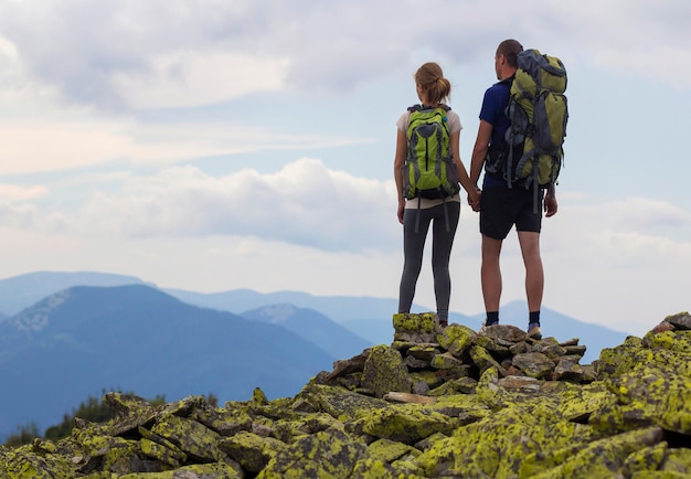 Back view of young tourist couple with backpacks