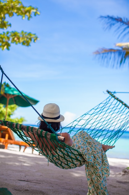 Back view of Young woman enjoying vacation in the hammock