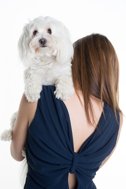 Back view of a young woman,  with her white dog, huging it.