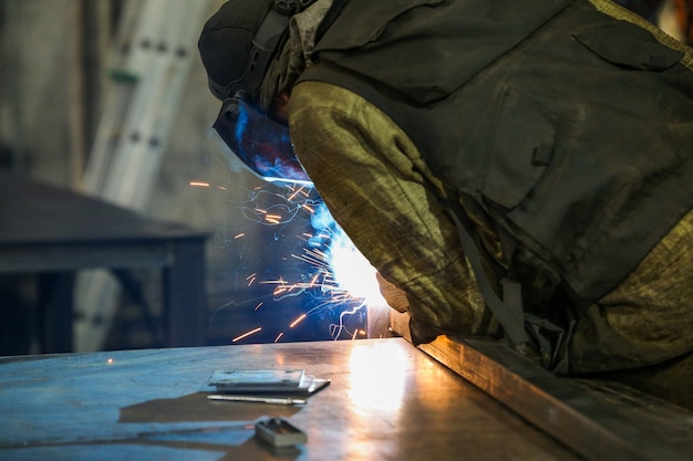 the back of a welder who works indoors