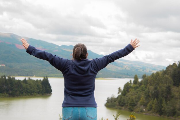 back of woman with blue jacket and landscape background