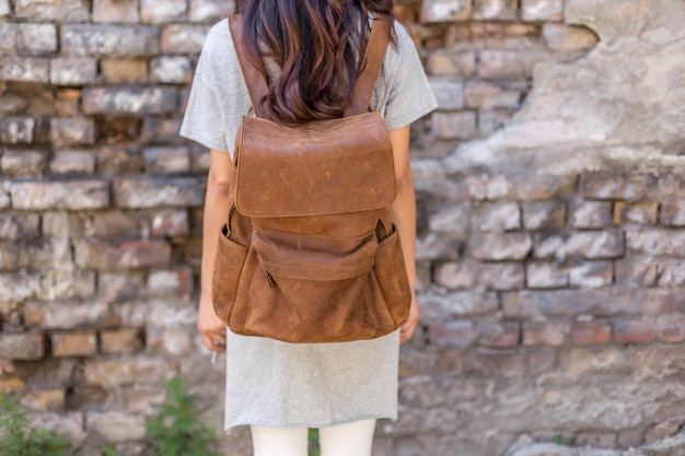 Back of woman with brown leather backpack