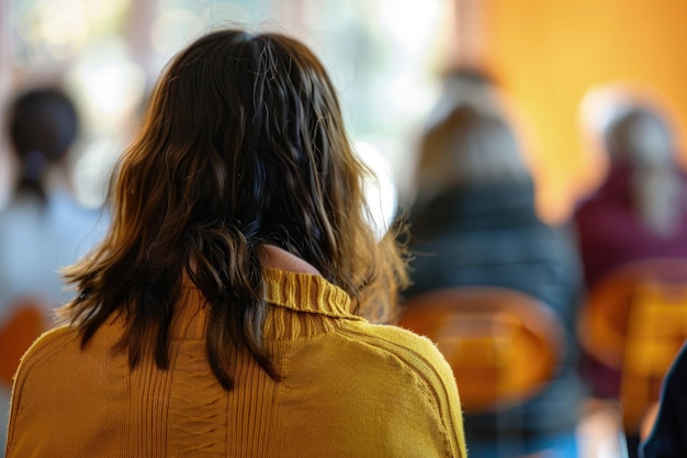 The back of a womans head as she sits at a table