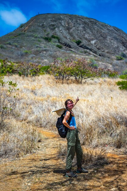 backapcker girl stands at the foot of the famous koko crater railway trailhead, oahu, hawaii, hiking