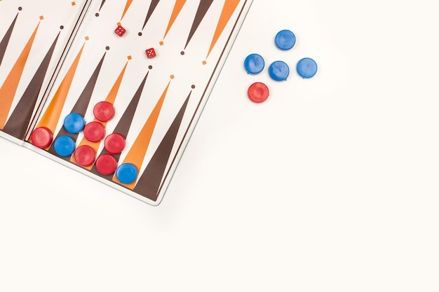 A backgammon board with red and blue checkers and small dices on a white background