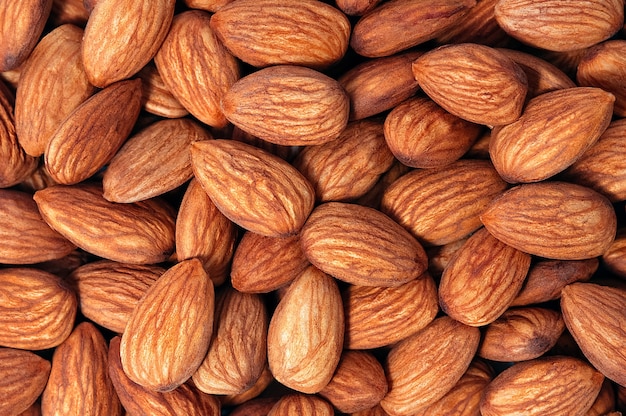 Background of almonds. Fried almonds. Scattered almond grains. Background for advertising, layout, mockup.