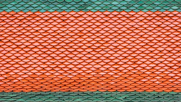 Фото Фон и текстура красочной зеленой и оранжевой керамической черепицы на крыше тайского храма