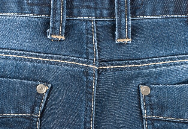 The background of the back pocket of blue jeans